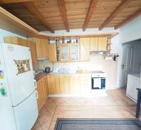 Küche mit Holzboden und Deckenbalken in einer Zweizimmerwohnung.