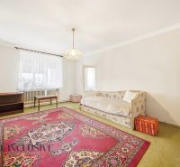 Wohnzimmer in einem Einfamilienhaus mit Teppich und Sofa, schlichtes Interieur.