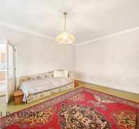 Ein Zimmer in einem Einfamilienhaus mit einem Bett, Licht und einem orientalischen Teppich.