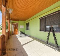 Ein Einfamilienhaus in Hviezdoslavov mit dekorierter Terrasse und Pflastersteinen, hellgrüner Putz.