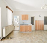 Eine Küche in einem Einfamilienhaus mit einem Boden in Holzoptik und Holzschränken.