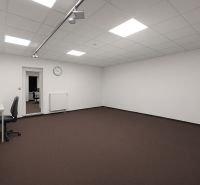 Geräumige Büros mit weißen Wänden, braunem Teppichboden und minimalistischer Einrichtung.