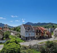 Ein Blick auf die Gebäude und Straßen in Ružomberok, mit grünen Hügeln im Hintergrund.