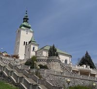 Eine Kirche mit einem Turm, umgeben von einer Treppe und Grünflächen in Ružomberok.