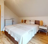 Helles Schlafzimmer in der Hütte mit Holzboden und großem Bett.