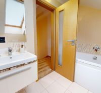 Badezimmer in der Hütte mit Badewanne, Waschbecken und Fliesenboden.