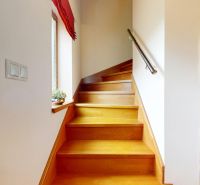 Innenraum einer Treppe mit Holzboden und Geländer in einer Hütte.