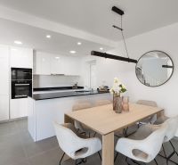Esszimmer in einer 2-Zimmer-Wohnung mit geräumigem Tisch und Küche.