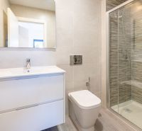 Badezimmer in einer Ferienwohnung mit großer Dusche und elegantem Waschbecken.