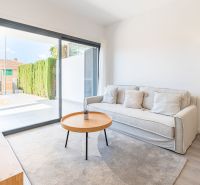 Ferienwohnung mit bequemem Sofa, Tisch und großem Fenster.