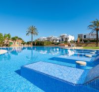 Schwimmbad bei der Ferienwohnung in Cala Murada auf Mallorca mit Palmen und Liegestühlen.