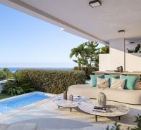 Terrasse einer Ferienwohnung in Estepona mit Pool, Meerblick und komfortabler Sitzgelegenheit.
