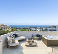 Terrasse in einer Ferienwohnung in Estepona mit modernen Möbeln, Whirlpool und Meerblick.