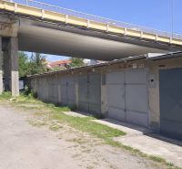Garagen in der Jesenského-Straße in Zvolen unter der Brücke, umgeben von Grünflächen und einem Schotterweg.