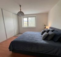 Schlafzimmer in einem Einfamilienhaus mit Bett, Holzboden und Einbauschrank.