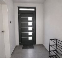 Im Inneren sehen wir eine Eingangstür, weiße Wände und Fliesen mit Schlüsseln auf dem Boden.