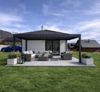 Ein Einfamilienhaus in Ižipovce mit Terrasse, Sitzgelegenheit im Garten, Grünflächen in der Umgebung.