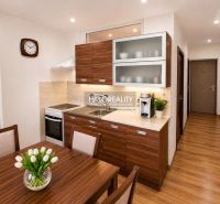 Küche in einer Einzimmerwohnung mit Holzdekor und einfacher Einrichtung.