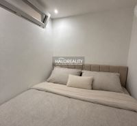 Gästezimmer in einer Einzimmerwohnung mit minimalistischem Design und komfortablem Bett.