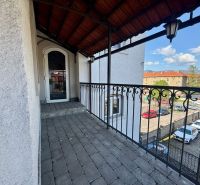 Ein Balkon mit einem Eisengeländer und Blick auf einen Parkplatz in Banská Bystrica. Ungewöhnliche Immobilien.