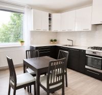 Küche in einer 3-Zimmer-Wohnung mit Esstisch und Boden in Holzoptik.