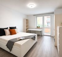 Schlafzimmer in einer 3-Zimmer-Wohnung mit Bett, Tisch und Holzboden.