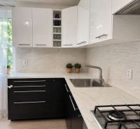 Küche in einer 3-Zimmer-Wohnung mit weißen Schränken und Spüle.