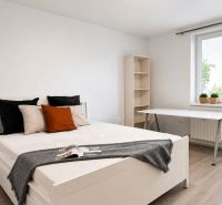 Helles Schlafzimmer in einer 3-Zimmer-Wohnung mit Holzboden und Schreibtisch.
