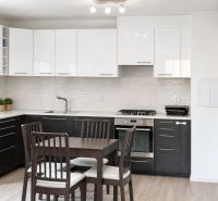 Küche in einer 3-Zimmer-Wohnung mit Esstisch und Boden in Holzoptik.
