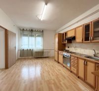 Küche in einem Einfamilienhaus mit heller Küchenzeile und Boden in Holzoptik.