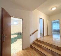 Eine Treppe mit einem Boden in Holzoptik, die in einem Einfamilienhaus ins Badezimmer führt.