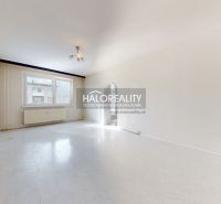 Ein geräumiges Zimmer mit einem großen Fenster in einer 3-Zimmer-Wohnung, Boden mit Holzdekor.