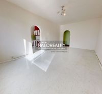 Ein geräumiges Zimmer in einer 3-Zimmer-Wohnung mit weißem Boden und bogenförmigen Durchgängen.