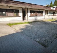 Geschäftsräume in Turzovka mit einfacher Fassade und gepflastertem Zugang.