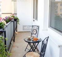 Ein Balkon mit Blumen und Sitzgelegenheiten in einer 3-Zimmer-Wohnung in Trnava.