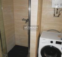Badezimmer mit Waschmaschine und Duschkabine in einer 3-Zimmer-Wohnung.