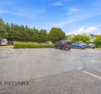 Parkplatz in Nitra, umgeben von Grünflächen und Autos in Gastrobereichen.