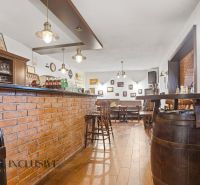 Backsteinbar und -hocker in Gastronomieräumen mit Holzboden.
