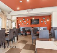 Restaurantinnenraum mit orangefarbener Wand, Sitzgelegenheiten und Dekorationen in gastronomischen Räumen.