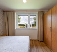 Schlafzimmer mit Holzboden und Blick aus dem Fenster in einem Einfamilienhaus.