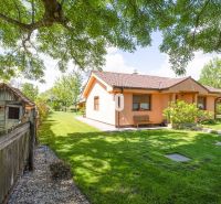 Ein Einfamilienhaus in Bílkove Humence, umgeben von einem Garten mit Bäumen und Rasen.