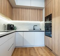 Küche in einer 3-Zimmer-Wohnung mit Holzboden und eingebauten Geräten.