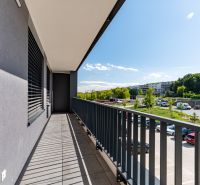 Balkon einer 3-Zimmer-Wohnung in Košice - Západ mit Blick auf Grünflächen und einen Parkplatz.