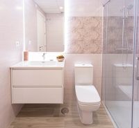 Badezimmer in einer Ferienwohnung mit Holzboden und Duschkabine.