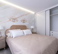 Ferienwohnung mit dekorativen Elementen, Doppelbett und Holzboden.