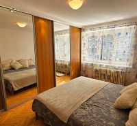 Schlafzimmer mit Schränken mit Schiebetüren und großem Spiegel in einer Zweizimmerwohnung.