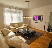Wohnzimmer mit weißem Sofa und Holzboden in einer 2-Zimmer-Wohnung.