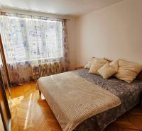 Schlafzimmer in einer 2-Zimmer-Wohnung mit Holzboden und großem Spiegel.