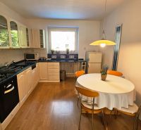 Helle Küche in einer 2-Zimmer-Wohnung mit Gasherd und Holzboden.