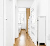 Ein heller Flur mit Holzboden und Eingängen zu den Zimmern in einer 2-Zimmer-Wohnung.